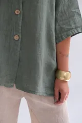 Camisa verde seco de lino italiano, con cuello mao, manga 3/4 y cierre frontal con botones.