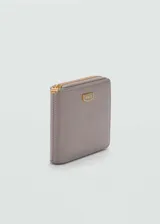 Billetera color beige con efecto piel, logo estampado y cierre de cremallera. Incluye bolsillo interior, múltiples ranuras para tarjetas y ranura exterior.