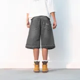 Bermuda de jean negra de corte ancho con terminaciones desflecadas.