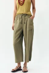Pantalón color verde oliva de tiro alto, corte ancho y largo 7/8. Tiene cintura elástica ajustable con cordón, bolsillos de plastrón en delantero y espalda.