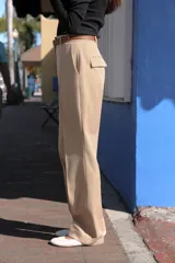 Pantalón negro de tiro alto con pernera recta, bolsillos frontales y falsos bolsillos con solapa en la espalda. Incluye cinturón marrón de cuero sintético.