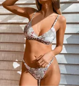 Conjunto de bikini blanco con estampado de manchas negras. El corpiño es de triángulo fijo con tirantes finos y la bombacha es tipo less regulable.