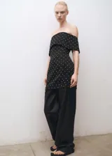 Vestido corto negro de tejido satinado con apliques brillantes, escote palabra de honor y diseño entallado. Cierre de cremallera en la parte posterior y forro interior.