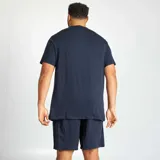 Conjunto de pijama para hombre, compuesto por una remera azul marino con estampado frontal de letras "NYC" en blanco y un short azul marino liso.