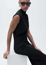 Vestido midi negro sin mangas, con cuello asimétrico, diseño entallado y cintura drapeada.