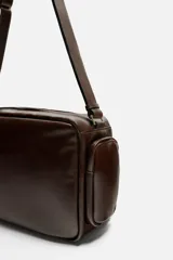 Bandolera marrón de piel envejecida con compartimento principal con cremallera, bolsillo interior plano y con cremallera, dos bolsillos frontales con botón a presión, dos bolsillos laterales con cremallera y asa de hombro ajustable de piel.