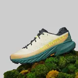 Championes de trail running Merrell Agility Peak 5, color beige con detalles en verde y negro. Cuentan con suela Vibram Megagrip, entresuela de espuma FloatPro y empeine de malla transpirable.