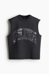 Musculosa negra con cuello redondo y sisas amplias. Estampado frontal con texto en color gris. Corte oversized.