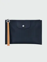 Estuche Longchamp modelo Le Pliage, color azul marino, con cierre superior y tira de cuero color caramelo.