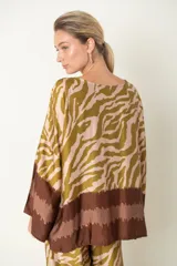 Blusa italiana con estampado de cebra y guarda en el bajo, de corte holgado y manga tres cuartos.