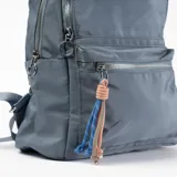 Mochila celeste con dos compartimentos principales con cierre, un bolsillo frontal con cierre y dos bolsillos laterales abiertos.