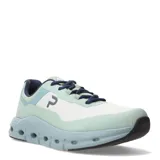 Championes urbanos con capellada de mesh blanca, refuerzos laterales y puntera en verde agua, detalles en azul marino y suela celeste con perforaciones.