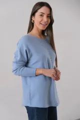 Sweater celeste de punto con corte recto y cuello redondo. Presenta detalle de líneas verticales formadas con el mismo hilado en la parte delantera.