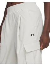 Pantalón cargo Under Armour Unstoppable para mujer, color blanco hueso, de corte holgado, con cintura elástica, bolsillos laterales y logo bordado en la pierna.