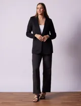 Blazer color beige, entallado, con cuello con solapa, abertura central con botón y bolsillos delanteros.