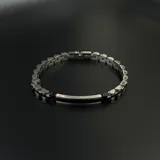 Pulsera de eslabones de acero plateado con placa central rectangular con interior negro.