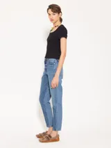 Jeans tipo mom fit de tiro alto, con detalles desflecados en los laterales y diferencia de tonos en el tejido.