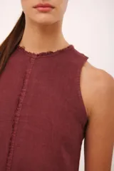 Vestido corto negro de lino italiano, con cuello redondo a la base y musculosa. Tiene detalle de desflecado en el cuello y a lo largo del vestido.