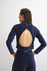 Pantalón de terciopelo azul marino, de corte sastrero amplio con pinzas, bolsillos laterales y largo al tobillo.