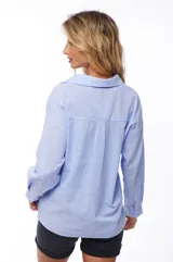 Camisa celeste de manga larga con cuello clásico y bolsillo en el pecho.