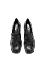 Zapato tipo mocasín color negro charol con relieve de cocodrilo, punta cuadrada y tacón bajo.