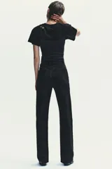 Pantalón de jean azul oscuro, de tiro alto, corte wide leg y largo hasta el tobillo.