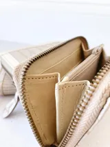 Billetera pequeña de cuero color beige con cierre metálico y monedero interno.