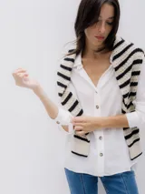 Camisa blanca de manga larga con cuello clásico, cierre de botones y corte holgado.