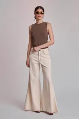 Musculosa marrón de tejido liso, con cuello redondo y tachas metálicas decorativas en los hombros.