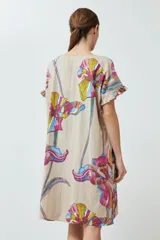 Vestido beige con estampado de flores de colores, corte recto y mangas cortas con volados.