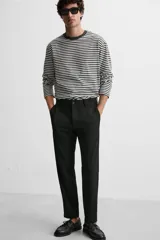 Pantalón slim fit negro confeccionado en tejido con elasticidad en ambas direcciones. Cuenta con bolsillos frontales y traseros de vivo con botón. Cierre frontal con cremallera y botón.