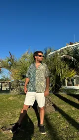 Camisa de manga corta con estampado abstracto en tonos verde, beige y negro.