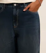 Pantalón de jean azul oscuro, corte balloon, con cintura con trabillas, cierre tradicional y bolsillos.