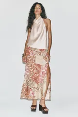 Falda midi de tiro alto con estampado paisley en tonos beige, rosa y marrón. Presenta frunces y cordón lateral, abertura en el bajo y cierre lateral con cremallera oculta.