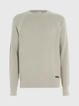 Sweater de punto texturizado color beige, con cuello redondo y ajuste regular.