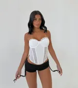 Corset blanco con encaje floral, corte strapless y ballenas verticales.