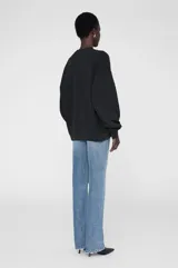 Buzo negro de cuello redondo con ajuste holgado y extragrande, confeccionado en vellón de peso medio con interior cepillado. Presenta un gráfico de parche de chenilla con la inscripción "Anine Bing" en el pecho.