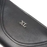Billetera grande (tipo fichero) color negro, fabricada en cuero sintético (PU). Presenta un diseño con costuras decorativas en forma de curva en la tapa frontal y el logo metálico 'XL' en tono plateado. Cuenta con cierre perimetral metálico y herrajes plateados.