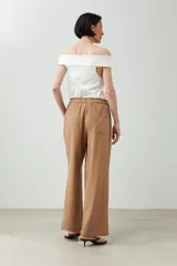 Pantalón de lino color marrón claro, de corte recto y tiro alto, con cintura elástica ajustable con cordón.