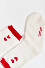 Par de medias blancas con puño rojo, dos corazones rojos bordados y logo "CaroCuore" en rojo.