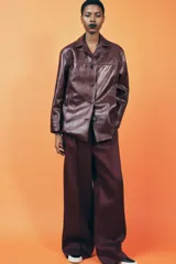 Cazadora de cuero color borgoña, con cuello solapa, manga larga, bolsillos de vivo en delantero y cierre frontal con botones.