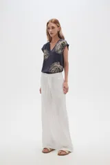 Pantalón blanco de rayon, corte ancho y tiro medio, con lazo ajustable en la cintura.