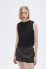 Musculosa negra con textura arrugada, cuello redondo y corte ajustado.