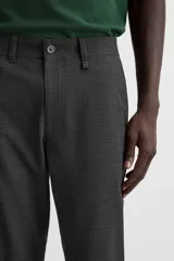 Pantalón slim fit negro confeccionado en tejido con elasticidad en ambas direcciones. Cuenta con bolsillos frontales y traseros de vivo con botón. Cierre frontal con cremallera y botón.
