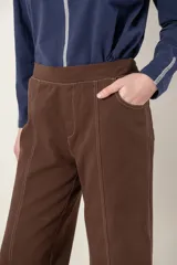 Pantalón de pana verde militar, de corte recto y tiro alto, con bolsillos laterales y traseros, y elástico en la cintura trasera.