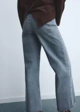 Jeans de mujer color azul claro, de tiro alto, corte wide leg y largo tobillero. Presenta bajo deshilachado, cierre de cremallera y botón, trabillas y bolsillos traseros.