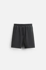 Bermuda de corte relaxed fit color gris oscuro, con cintura elástica ajustable con cordón, bolsillos frontales y bolsillo trasero de plastrón.