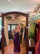 Vestido largo negro con escote en V, cut outs laterales bajo el busto y breteles finos cruzados y atados en la espalda.