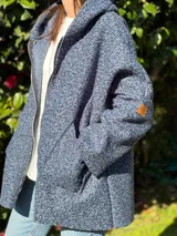 Campera color ocre con capucha y cierre frontal asimétrico.
