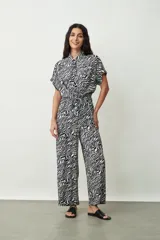 Mono largo de viscosa con estampado de cebra en blanco y negro, con cuello camisero, mangas cortas y lazo en la cintura.